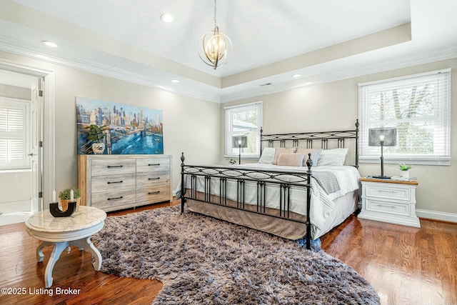 bedroom with ornamental molding, dark hardwood / wood-style flooring, a raised ceiling, and a notable chandelier