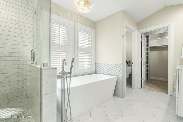 bathroom featuring tile walls, toilet, independent shower and bath, and vaulted ceiling