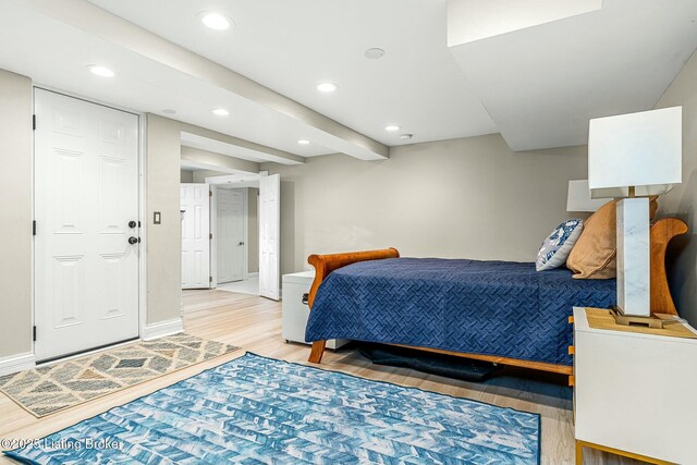 bedroom with light wood-type flooring and beamed ceiling