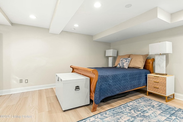 bedroom featuring fridge, beam ceiling, and light wood-type flooring