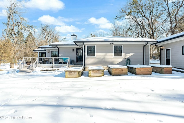 view of snow covered back of property