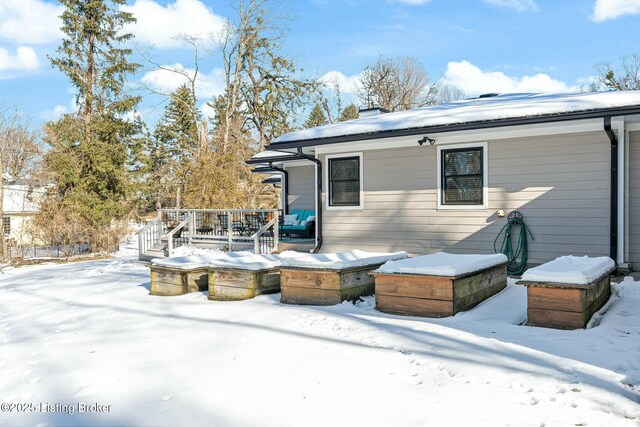 snow covered rear of property featuring a wooden deck