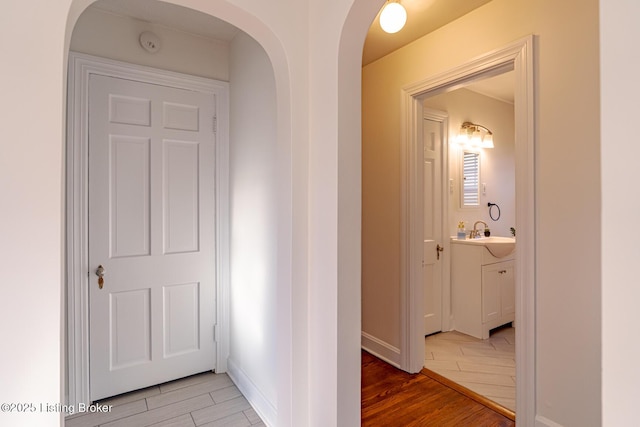 hallway with wood-type flooring and sink