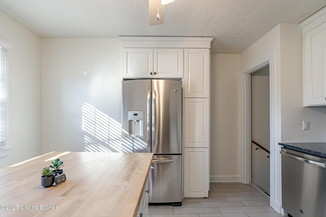 kitchen with white cabinetry, appliances with stainless steel finishes, wooden counters, and a textured ceiling