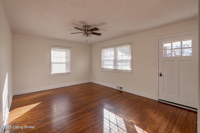 entryway featuring ceiling fan, dark hardwood / wood-style flooring, and a textured ceiling