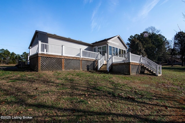 rear view of house featuring a deck and a yard