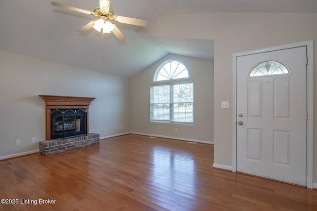 entryway with vaulted ceiling, ceiling fan, a fireplace, and hardwood / wood-style floors