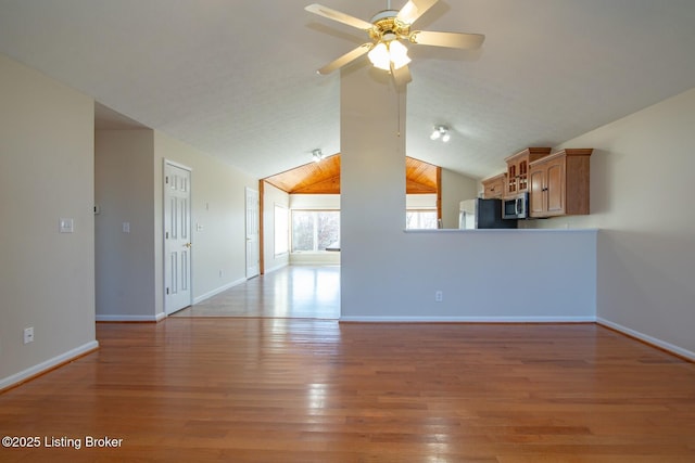 unfurnished living room featuring vaulted ceiling, ceiling fan, and light hardwood / wood-style floors