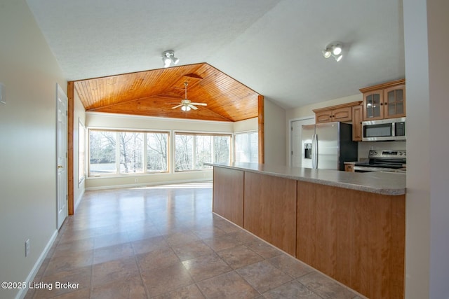 kitchen with ceiling fan, stainless steel appliances, wood ceiling, and a wealth of natural light