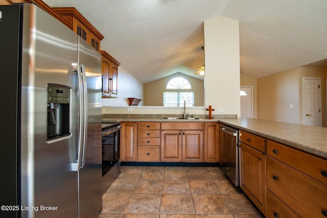 kitchen with kitchen peninsula, ceiling fan, stainless steel appliances, vaulted ceiling, and sink