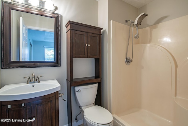 bathroom featuring toilet, walk in shower, and vanity