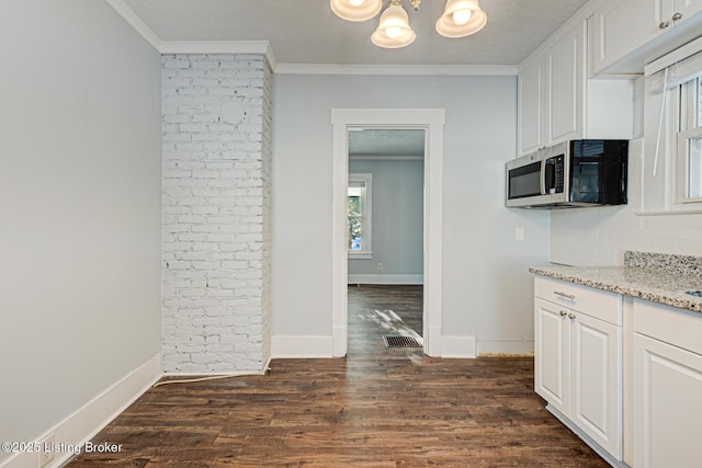 kitchen with dark hardwood / wood-style floors, ornamental molding, and white cabinets