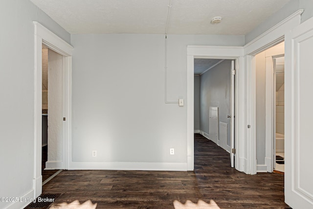 spare room with a textured ceiling and dark wood-type flooring