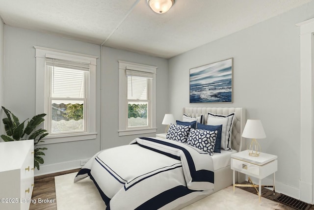 bedroom with a textured ceiling and hardwood / wood-style floors