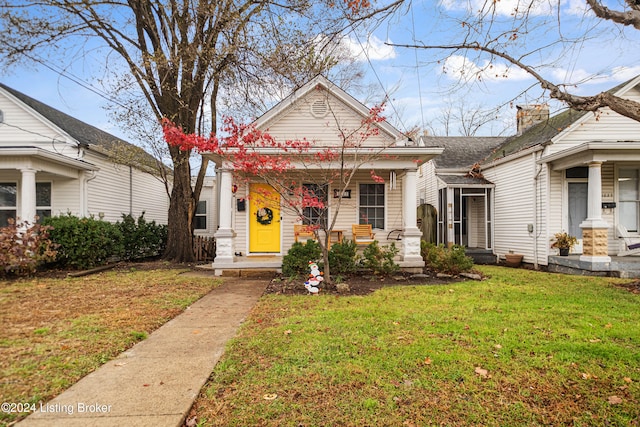 bungalow-style home with a front lawn and a porch