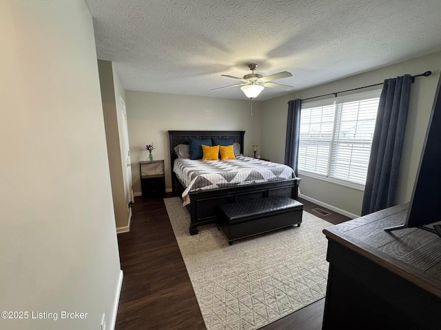 bedroom featuring ceiling fan, dark hardwood / wood-style floors, and a textured ceiling