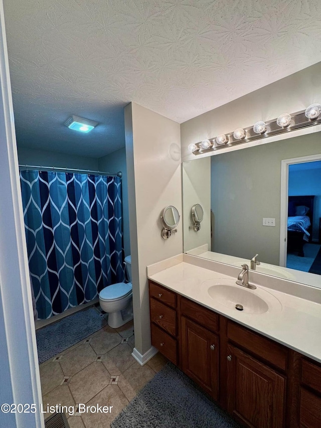 bathroom with vanity, toilet, and a textured ceiling