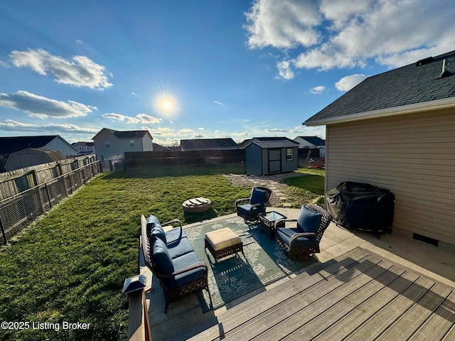 wooden terrace featuring outdoor lounge area, a yard, grilling area, a storage shed, and a patio