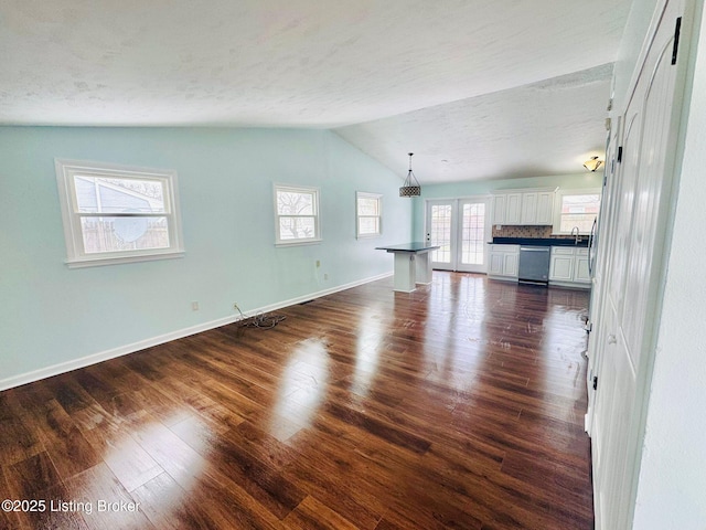 unfurnished living room featuring vaulted ceiling and dark hardwood / wood-style floors