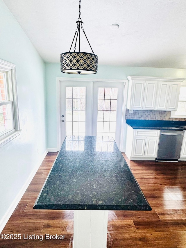 kitchen featuring decorative backsplash, dark hardwood / wood-style floors, dishwasher, pendant lighting, and white cabinets