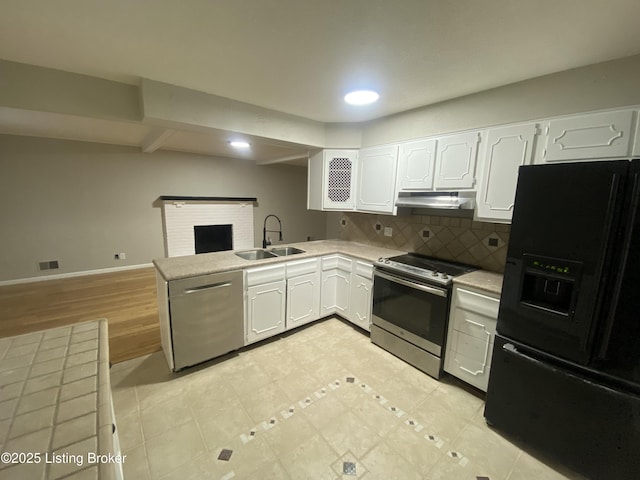 kitchen with backsplash, white cabinets, sink, kitchen peninsula, and stainless steel appliances