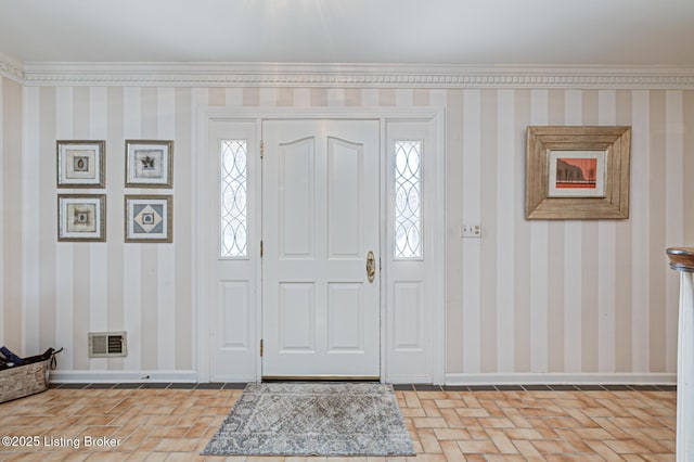 entryway featuring ornamental molding and plenty of natural light