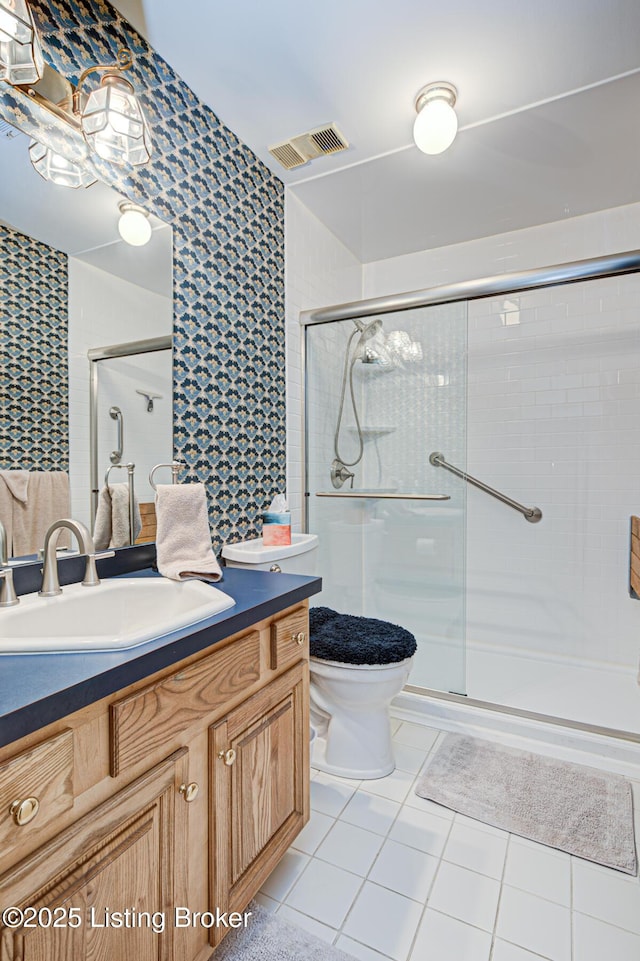 bathroom with toilet, tile patterned flooring, an enclosed shower, and vanity