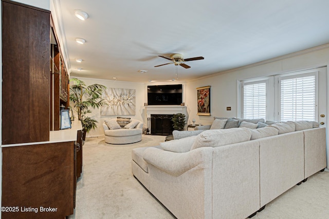 living room with ceiling fan, ornamental molding, and light carpet