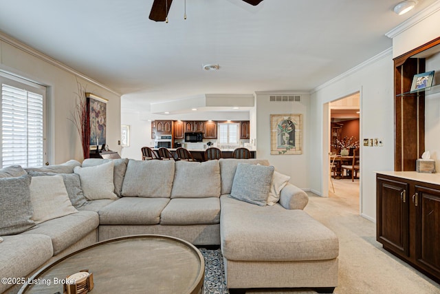 carpeted living room featuring ceiling fan and ornamental molding