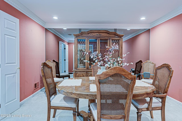 carpeted dining space featuring crown molding