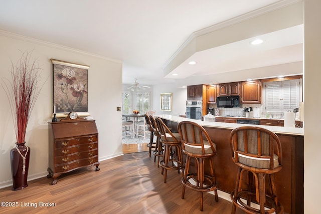 161 Gardiner Lake Rd Unit 161, Louisville, KY 40205 - kitchen with stainless steel oven, a kitchen breakfast bar, dark wood-type flooring, crown molding, and tasteful backsplash