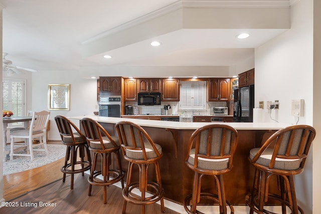 161 Gardiner Lake Rd Unit 161, Louisville, KY 40205 - kitchen with black appliances, tasteful backsplash, a breakfast bar area, light countertops, and recessed lighting