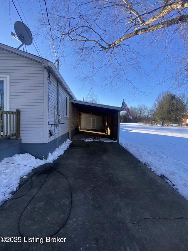 snow covered property featuring a carport