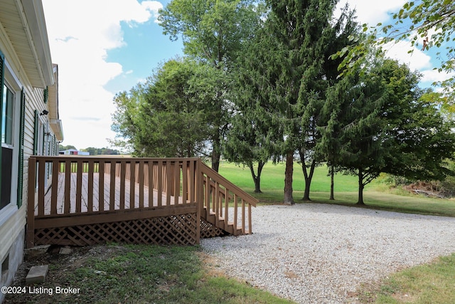 wooden terrace featuring a lawn