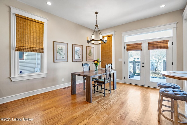 dining area featuring a notable chandelier, light hardwood / wood-style floors, and french doors