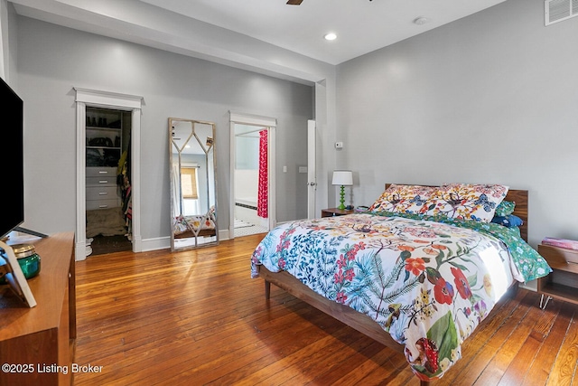 bedroom with hardwood / wood-style flooring, a walk in closet, and a closet