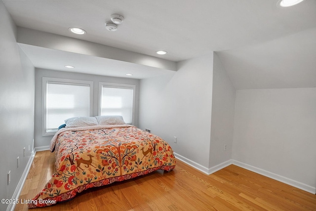 bedroom with vaulted ceiling and light hardwood / wood-style floors