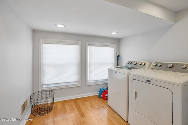 laundry area with light hardwood / wood-style flooring and independent washer and dryer