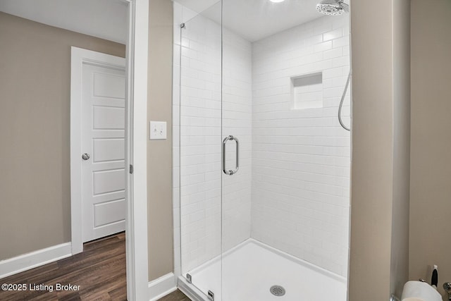 bathroom with hardwood / wood-style flooring and a shower with shower door