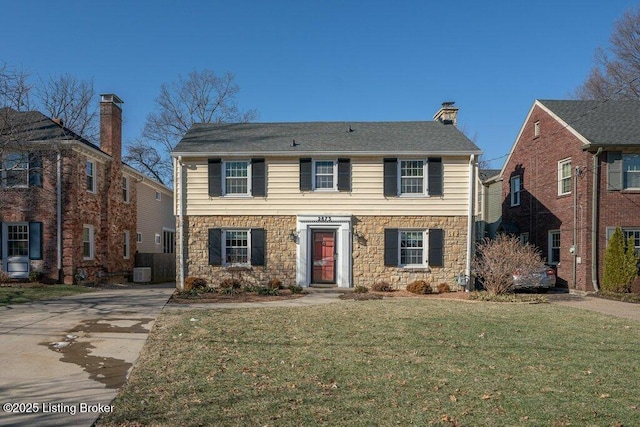 colonial-style house featuring a front yard