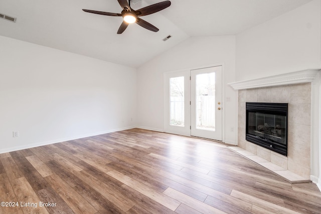 unfurnished living room featuring a tile fireplace, ceiling fan, light hardwood / wood-style flooring, and lofted ceiling