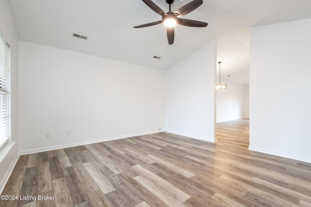 empty room with light wood-type flooring, ceiling fan, and lofted ceiling