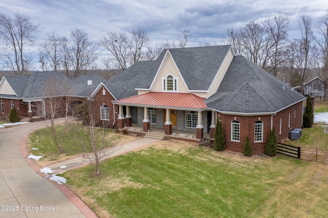 view of front of property with central AC, covered porch, and a front lawn