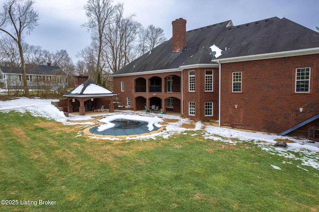 snow covered property featuring a gazebo and a lawn