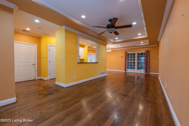 unfurnished living room featuring dark hardwood / wood-style flooring, crown molding, a raised ceiling, and ceiling fan