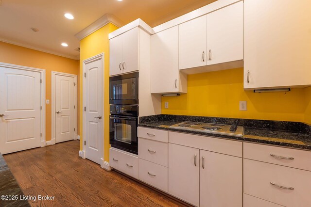 kitchen with white cabinetry, dark stone counters, cooktop, and dark wood-type flooring