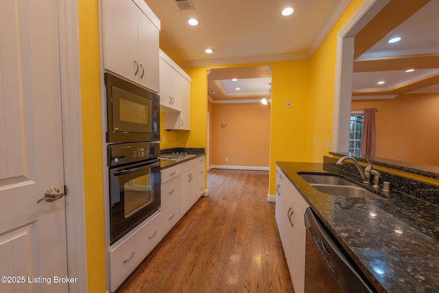 kitchen with white cabinetry, sink, dark stone countertops, ornamental molding, and black appliances