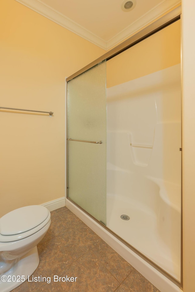 bathroom featuring ornamental molding, a shower with shower door, and toilet