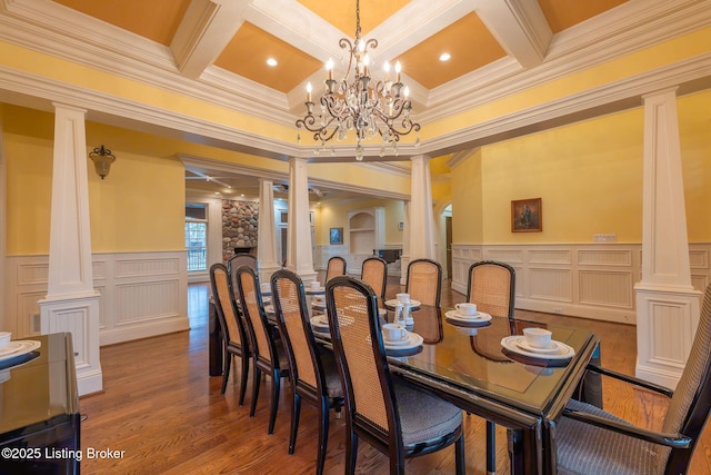 dining space featuring hardwood / wood-style flooring, beam ceiling, and ornate columns