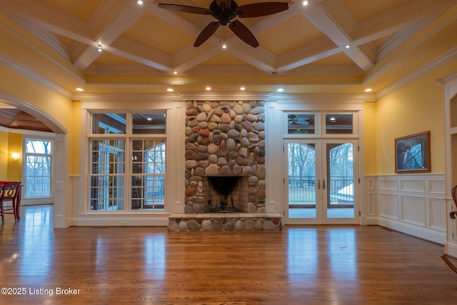 unfurnished living room featuring hardwood / wood-style flooring, coffered ceiling, a fireplace, french doors, and beamed ceiling